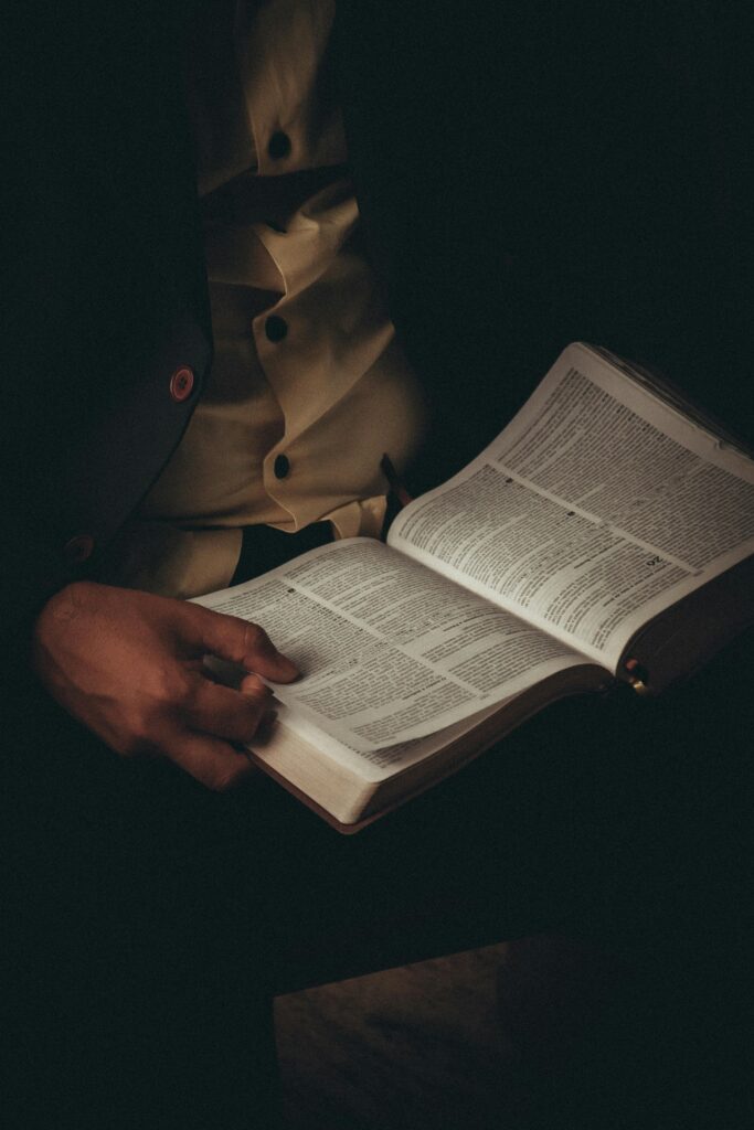 Person reading inspirational book to stay motivated during tough times.