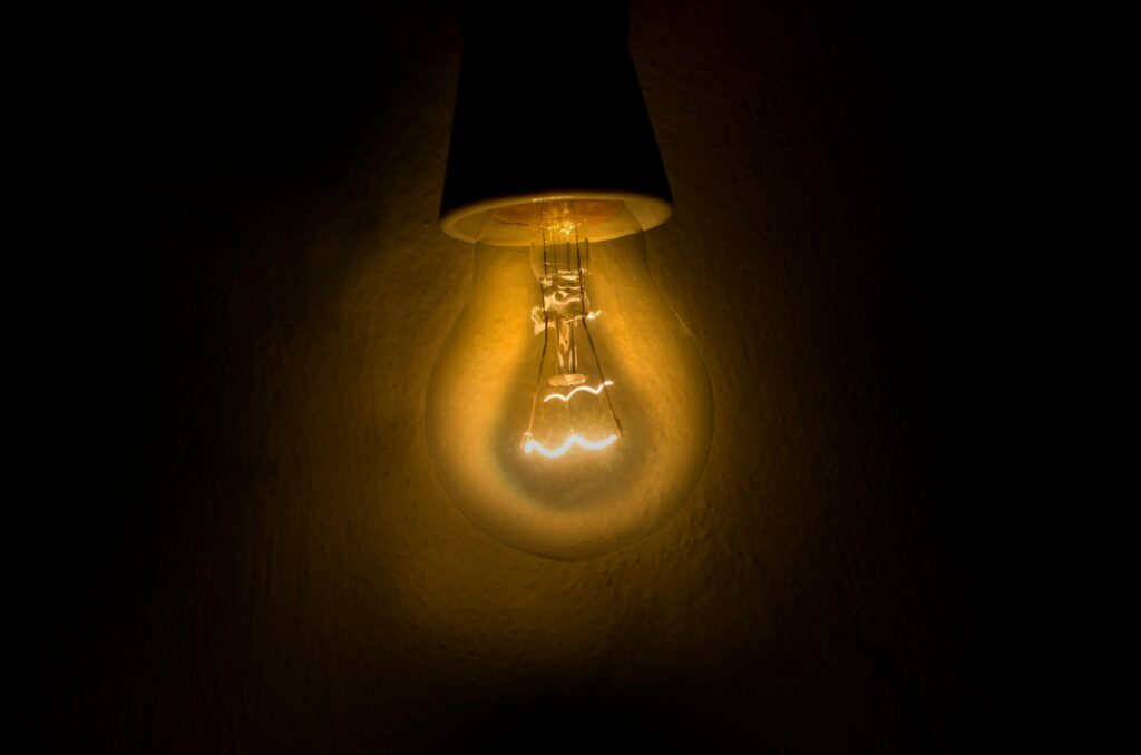 A light bulb glowing brightly symbolizing resilience and learning.
